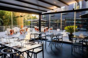 a restaurant with tables and chairs and large windows at Black Hotel in Rome