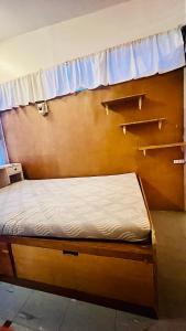 uma pequena cama num quarto com uma janela em Kingking and Gonggong’s Boardinghouse em San Carlos