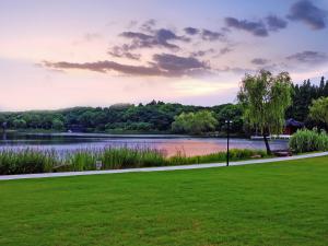 上海市にあるShanghai Dongjiao State Guest Hotelの湖と芝生の畑がある公園