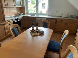 a kitchen with a wooden table with two bottles of wine at Ferienwohnung Hellwig in Medebach