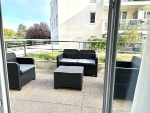 einen Balkon mit Stühlen und einem Tisch auf einem Gebäude in der Unterkunft Perle rare « Le Cosy de CDG » in Le Blanc-Mesnil