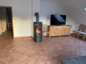 a living room with a fireplace and a tv at Ferienwohnung Hellwig in Medebach