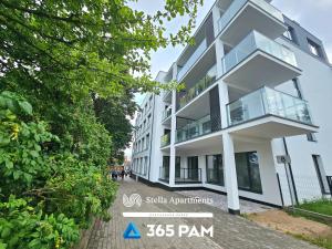 a white building with glass windows on a street at 365PAM - Apartament Leaf 6-osobowy in Ustronie Morskie +18 photos
