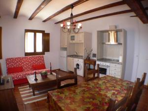 a kitchen and living room with a table and a couch at 1g CASA DE LOS FERNANDEZ RAJO in Orihuela del Tremedal