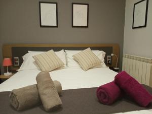 オウレンセにあるAp Dúplex en Casco Históricoのベッドルーム1室(白いベッド1台、紫色のタオル付)