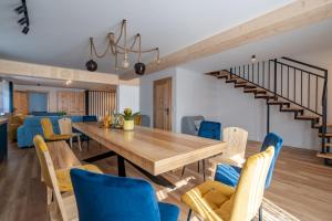 une salle à manger avec une table en bois et des chaises bleues dans l'établissement Tatrzańskie Wieczory, à Zakopane