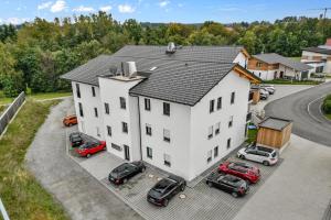 a large white house with cars parked in a parking lot at Smurmelhomes Oase: Terrasse - Parken - Kind in Passau