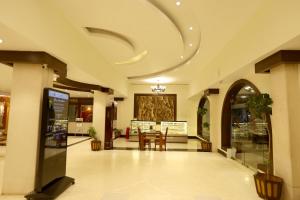 eine Lobby mit einem Tisch und Stühlen in einem Gebäude in der Unterkunft Breeze Residency in Tiruchchirāppalli