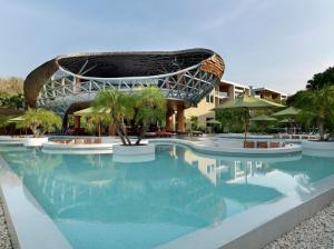 a swimming pool with a building in the background at Wyndham Grand Nai Harn Beach Phuket in Nai Harn Beach