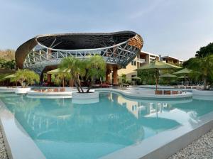 une piscine avec un bâtiment en arrière-plan dans l'établissement Wyndham Grand Nai Harn Beach Phuket, à Nai Harn Beach