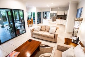 a living room with a couch and a table at Chez Brolga in Port Douglas