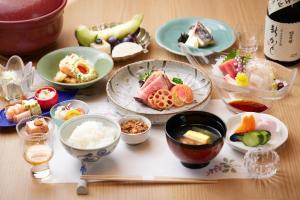 una mesa con platos de comida y tazones de comida en Shin Kadoya, en Atami