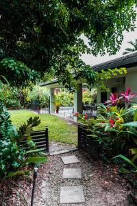 a garden with a bench and some plants at Chez Brolga in Port Douglas