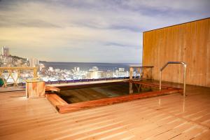 a hot tub on the roof of a building at Shin Kadoya in Atami