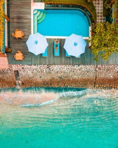 - une vue sur la piscine bordée de parasols dans l'établissement Sunrise Cottage, à Nusa Penida