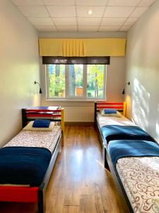 two beds in a room with a window at Tamme staadioni hostel in Tartu