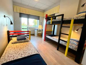 a room with three bunk beds and a desk at Tamme staadioni hostel in Tartu