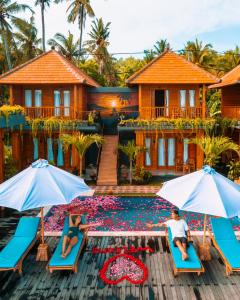 two people sitting on chairs in front of a house at Sunrise Cottage in Nusa Penida