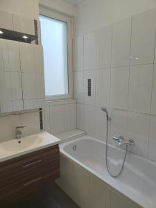 ein Badezimmer mit einer Dusche, einer Badewanne und einem Waschbecken in der Unterkunft Appartement familial, calme et spacieux in Straßburg