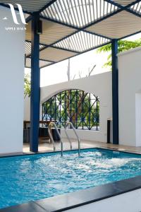 a swimming pool with blue water in a building at Apple Hause Venuestay in Phan Rang