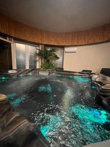 una piscina con luces azules en una habitación en Kinizsi Udvar Apartmanház, en Balatonboglár