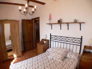 a bedroom with a bed and a chandelier at 1 P Casa de los Fernandez Rajo in Orihuela del Tremedal