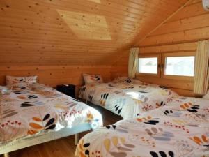 1 dormitorio con 2 camas en una cabaña de madera en 浅間山を眺めるフインランドログハウス en Kutsukake