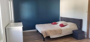 a bedroom with a bed with a blue wall at Magnifique appartement le marronnier in Xonrupt-Longemer