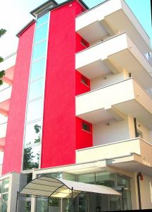 un bâtiment rouge avec un parapluie devant lui dans l'établissement Hotel Etoile, à Rimini