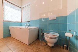 a bathroom with a toilet and a sink and a window at Villa Casablanca in Braşov