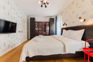 a bedroom with a large bed and a flat screen tv at Villa Casablanca in Braşov