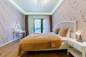 a bedroom with a bed and a table and a mirror at Villa Casablanca in Braşov