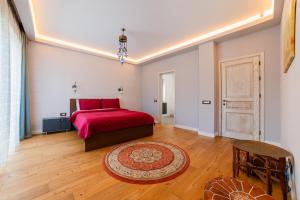 a bedroom with a red bed and a wooden floor at Villa Casablanca in Braşov