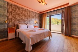 a bedroom with a bed and a large window at Villa Casablanca in Braşov