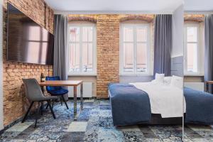 sypialnia z łóżkiem, stołem i oknami w obiekcie Apartamenty Browar Luxury Old Town Poznań Check In 24h w Poznaniu