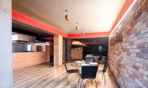 a dining room with a brick wall and a table and chairs at Treebo Trend Kings Orchid in Bangalore