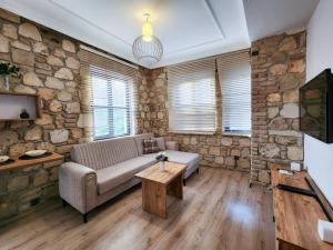 sala de estar con sofá y pared de piedra en Sera Homes Kaleici Oldtown, en Antalya