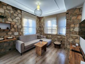 a living room with a couch and a stone wall at Sera Homes Kaleici Oldtown in Antalya