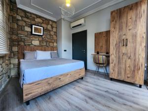 um quarto com uma cama e uma parede de pedra em Sera Homes Kaleici Oldtown em Antália