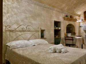 a bedroom with a bed with two towels on it at Il Vicolo Grottaglie in Grottaglie