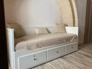 białe łóżko z poduszkami w pokoju w obiekcie Il Vicolo Grottaglie w mieście Grottaglie