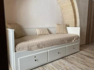 a white bed with pillows on it in a room at Il Vicolo Grottaglie in Grottaglie