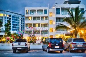 um grupo de carros estacionados em frente a um edifício em Naiya Sea Resort em Sihanoukville