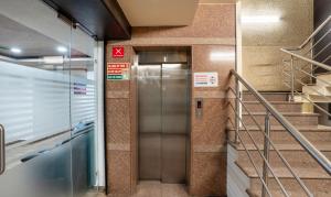 un ascenseur dans une station de métro avec des escaliers dans l'établissement Treebo Trend Kings Orchid, à Bangalore
