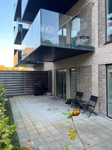 a patio with two chairs and a balcony on a building at Charming Aalborg Apartment With parking in Aalborg