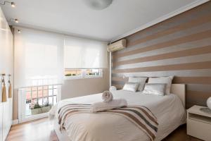 a bedroom with a large bed with a striped wall at Chalet independiente de diseño con Patio Privado in Madrid