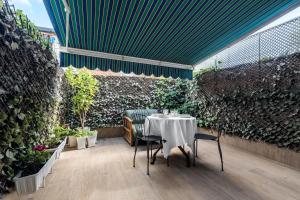 stół z krzesłami i zieloną ścianą w obiekcie Chalet independiente de diseño con Patio Privado w Madrycie