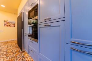 a kitchen with blue cabinets and a microwave at Villa Casablanca in Braşov