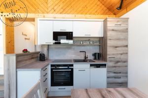 a kitchen with white appliances and a wooden ceiling at Mina&Hansl in Schladming