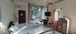 a bedroom with a bed and a large window at The Sunshine Bungalow in Bangalore